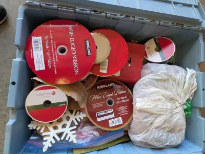 Assorted holiday crafting supplies, including Kirkland Signature wire-edged ribbon, Celebrate It ribbon, and a glittery snowflake...