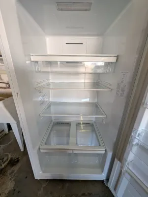 Interior view of a clean, modern white refrigerator featuring adjustable glass shelving and dual crisper drawers.