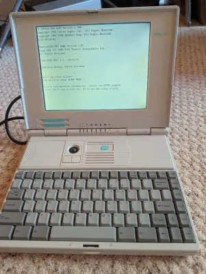 Vintage 4DX/33 laptop computer from the early 1990s, powered on and displaying a BIOS screen with a real-time clock failure message.