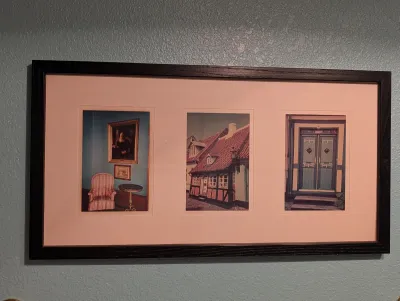 Framed triptych of photographs featuring European architectural and interior scenes, housed in a dark wood frame with a wide pink mat.