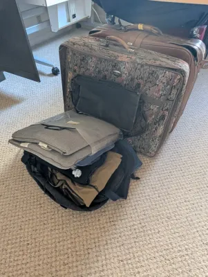 Vintage luggage set including a floral tapestry suitcase, a brown vinyl suitcase, and various travel bags.