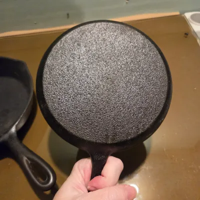 Sale Photo Thumbnail #428: Two cast iron skillets. #5 -  2 notch Lodge and a little skillet