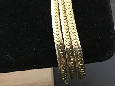 Sale Photo Thumbnail #264: Gold-tone triple-strand herringbone pattern chain bracelet. Features a fold-over clasp mechanism. Measures approximately 7 to 7.5 inches long. Excellent vintage condition with minimal surface wear.