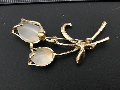 Sale Photo Thumbnail #286: Gold-tone floral brooch featuring two tulip blossom motifs set with translucent milky white/faux moonstone cabochons and accented with clear rhinestones. Measures approximately 2 inches in length. Features a rollover safety clasp on the back. Good vintage