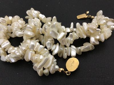 Sale Photo Thumbnail #122: Multi-strand freshwater pearl or mother-of-pearl chip/nugget necklace featuring a gold-toned clasp marked '14K TGF' (14K Gold Filled) with a cabochon accent insert. Clasp and strands appear intact and in good condition with minor vintage wear.