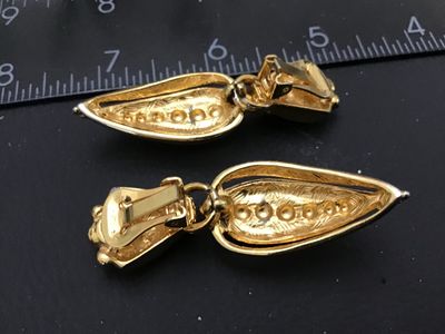Sale Photo Thumbnail #182: Pair of vintage gold-tone clip-on drop earrings featuring a ribbed, tear-drop shape design with beaded texture accents. Earrings measure approximately 2.5 inches in length. In good condition with minor surface wear consistent with age.