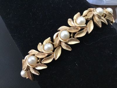 Sale Photo Thumbnail #4: Vintage costume jewelry bracelet featuring brushed textured gold tone leaf links accented with round faux pearls throughout. Includes a fold-over clasp. Good vintage condition with light, age-appropriate wear.