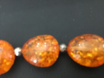 Sale Photo Thumbnail #12: Faux amber chunk bead statement bracelet featuring five large orange translucent, multi-faceted faux amber stones interspersed with textured silver-tone metal spacer beads. Finished with a decorative silver-tone toggle closure. Good condition with light s