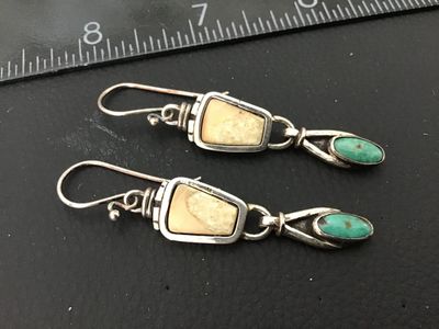 Sale Photo Thumbnail #13: Pair of handcrafted sterling silver Tone dangle drop earrings featuring bezel-set turquoise and light tan stone/jasper inlays. Features wire hooks with wire-wrap details. Overall good condition with light patina appropriate for age and wear.