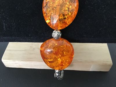 Sale Photo Thumbnail #9: Faux amber chunk bead statement bracelet featuring five large orange translucent, multi-faceted faux amber stones interspersed with textured silver-tone metal spacer beads. Finished with a decorative silver-tone toggle closure. Good condition with light s
