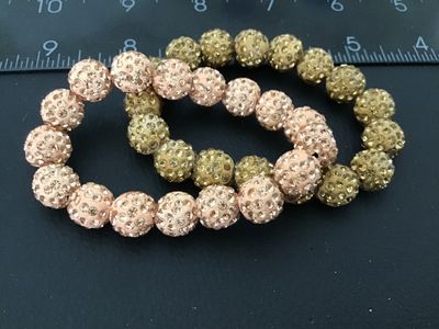 Sale Photo Thumbnail #33: Pair of beaded stretch bracelets featuring pave rhinestone 'disco ball' style beads in light pink/blush and gold tones. Good condition with no missing stones visible.