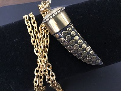 Sale Photo Thumbnail #45: A vintage gold-tone chain necklace featuring a horn-shaped pendant with detailed brass floral and stud inlays set in a dark background, capped in polished brass with twisted wire detail. The pendant measures approximately 1.5 to 2 inches long. Good vintag