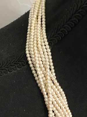 Sale Photo Thumbnail #201: Multi-strand faux pearl necklace featuring a knotted detail design in front and gold-tone spacer accent beads near the closure. Appears to be in good vintage condition with gentle surface wear. Perfect for elegant or formal occasions.
