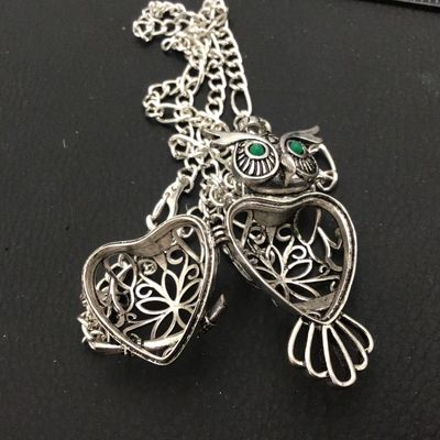 Sale Photo Thumbnail #79: Intricate silver-tone owl pendant with green faux stone/enamel eyes and an openwork filigree locket body that opens on a hinge. Attached to a silver-tone chain. Shows light general wear consistent with age and pre-owned use. Please see photos for detailed