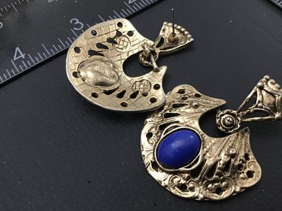 Sale Photo Thumbnail #228: Pair of ornate vintage gold-tone pierced drop/dangle earrings. Feature detailed filigree and pierced metalwork set with oval faux lapis lazuli or cobalt blue cabochons. Each earring measures approximately 1.5 to 2 inches long. Show light surface wear and 