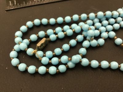 Sale Photo Thumbnail #109: Vintage multi-strand long necklace featuring light blue round beads separated by small dark spacer beads. Includes a gold-tone filigree push-in box clasp. Good vintage condition with light wear consistent with age.