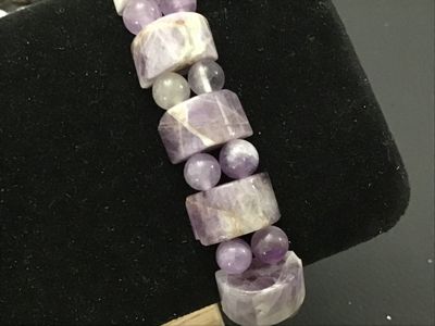 Sale Photo Thumbnail #158: Natural gemstone stretch bracelet featuring polished rectangular/cylindrical purple chevron amethyst beads alternating with round accent beads. Features natural variations, veining, and matrix throughout the stones. Elastic band allows for easy wear. In g