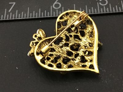 Sale Photo Thumbnail #254: Gold-tone heart-shaped brooch pin encrusted with red, dark red, and aurora borealis (AB) finish rhinestones, featuring butterfly motifs. Measures approximately 1.75 inches wide. Excellent pre-owned condition with all stones intact and functional rollover 