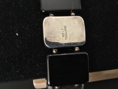 Sale Photo Thumbnail #20: Sterling silver and black onyx panel bracelet featuring alternating rectangular sterling silver segments and smooth black onyx panels on a stretch cord. Marked '925 LT THAILAND' on the back of a silver panel. Shows minor tarnishing and surface wear consis