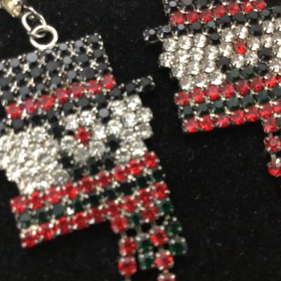 Sale Photo Thumbnail #77: Pair of festive holiday dangle earrings featuring a detailed snowman design crafted from clear, black, red, and green rhinestones set in silver-tone metal. Earrings feature post-back closures and articulated fringe scarves. Appears in good condition with 