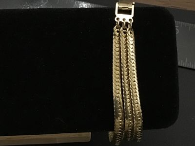 Sale Photo Thumbnail #263: Gold-tone triple-strand herringbone pattern chain bracelet. Features a fold-over clasp mechanism. Measures approximately 7 to 7.5 inches long. Excellent vintage condition with minimal surface wear.