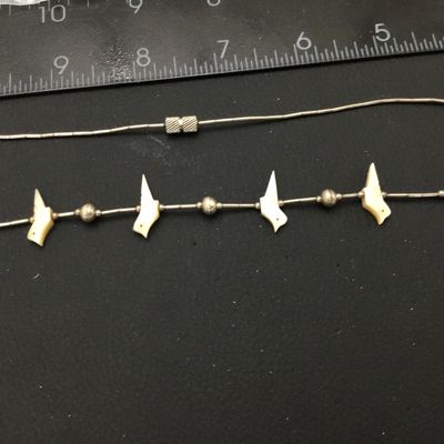 Sale Photo Thumbnail #83: Vintage Southwestern liquid silver tube bead necklace featuring carved mother-of-pearl or shell bird fetishes interspersed with silver round beads. Features a barrel screw clasp enclosure. Shows light patina and wear consistent with age.