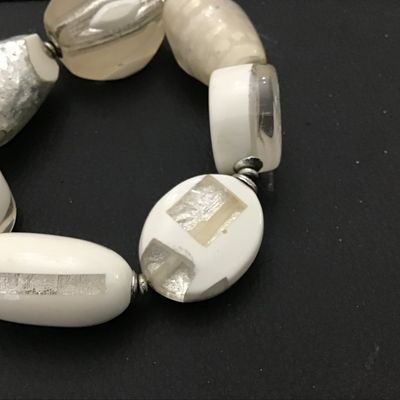 Sale Photo Thumbnail #89: A statement stretch bracelet featuring large, chunky art glass beads in opaque white, clear glass, and foil-lined accents. The beads come in various shapes including oval, round disc, and barrel forms, separated by small silvertone spacer beads. Good cond