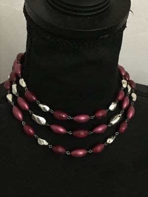 Sale Photo Thumbnail #173: A vintage multi-strand costume necklace featuring burgundy faceted and smooth oval beads interspersed with silver-tone freeform accents. Secured with an adjustable shepherd's hook clasp and decorative filigree end piece. Appears to be in good vintage cond
