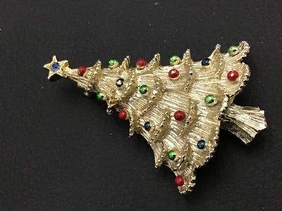 Sale Photo Thumbnail #270: Vintage Christmas tree brooch pin by Gerry's. Features a textured gold-tone finish embellished with colorful red, green, blue, and clear rhinestones and cabochons, topped with a star. Stamped GERRY'S© on the reverse. Measures approximately 2 inches in he