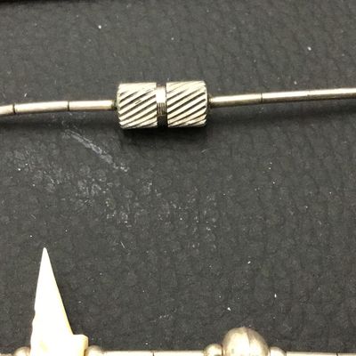 Sale Photo Thumbnail #85: Vintage Southwestern liquid silver tube bead necklace featuring carved mother-of-pearl or shell bird fetishes interspersed with silver round beads. Features a barrel screw clasp enclosure. Shows light patina and wear consistent with age.