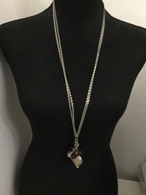 Sale Photo Thumbnail #136: Long silver-tone double-chain necklace featuring a detailed textured nautilus shell pendant clustered with faceted black and smoky glass beads. Good condition with light minor surface wear to the finish.