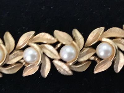 Sale Photo Thumbnail #7: Vintage costume jewelry bracelet featuring brushed textured gold tone leaf links accented with round faux pearls throughout. Includes a fold-over clasp. Good vintage condition with light, age-appropriate wear.