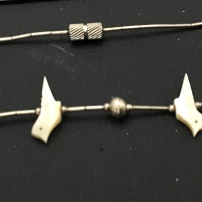 Sale Photo Thumbnail #86: Vintage Southwestern liquid silver tube bead necklace featuring carved mother-of-pearl or shell bird fetishes interspersed with silver round beads. Features a barrel screw clasp enclosure. Shows light patina and wear consistent with age.
