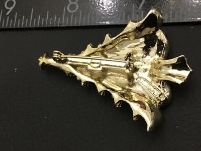 Sale Photo Thumbnail #271: Vintage Christmas tree brooch pin by Gerry's. Features a textured gold-tone finish embellished with colorful red, green, blue, and clear rhinestones and cabochons, topped with a star. Stamped GERRY'S© on the reverse. Measures approximately 2 inches in he