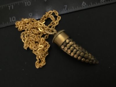 Sale Photo Thumbnail #44: A vintage gold-tone chain necklace featuring a horn-shaped pendant with detailed brass floral and stud inlays set in a dark background, capped in polished brass with twisted wire detail. The pendant measures approximately 1.5 to 2 inches long. Good vintag