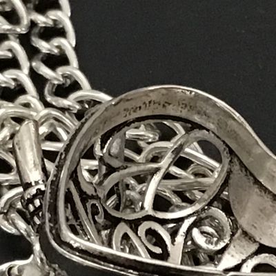 Sale Photo Thumbnail #80: Intricate silver-tone owl pendant with green faux stone/enamel eyes and an openwork filigree locket body that opens on a hinge. Attached to a silver-tone chain. Shows light general wear consistent with age and pre-owned use. Please see photos for detailed