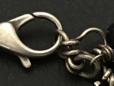 Sale Photo Thumbnail #148: A striking  925 chunky charm-style bracelet featuring large, faceted natural stone beads in shades of deep blue sodalite and white quartz or moonstone. The stones are attached to a silver-tone chain with a lobster claw clasp. The clasp appears to have fai