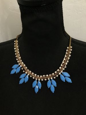 Sale Photo Thumbnail #103: A striking statement necklace featuring clear rhinestone chain links accented with a center gold-tone curblink chain, adorned with cluster dangles of bright blue opaque navette-cut stones in prong settings. Appears to be in good condition with all stones 