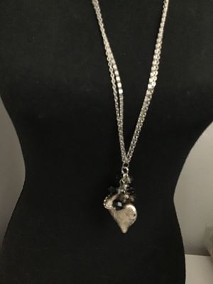 Sale Photo Thumbnail #135: Long silver-tone double-chain necklace featuring a detailed textured nautilus shell pendant clustered with faceted black and smoky glass beads. Good condition with light minor surface wear to the finish.