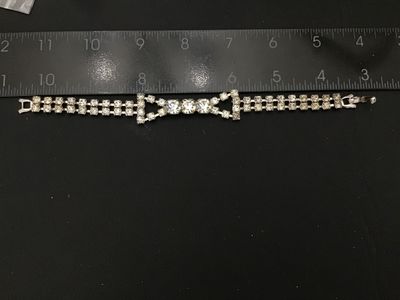 Sale Photo Thumbnail #39: Vintage silver-tone costume jewelry bracelet featuring a double strand of prong-set clear sparkling rhinestones with a central focal accent of larger round rhinestones. Features a fold-over clasp closure. Measures approximately 7 inches in length. In good