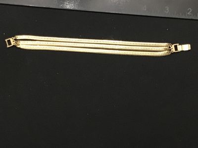 Sale Photo Thumbnail #265: Gold-tone triple-strand herringbone pattern chain bracelet. Features a fold-over clasp mechanism. Measures approximately 7 to 7.5 inches long. Excellent vintage condition with minimal surface wear.