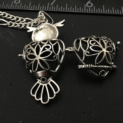 Sale Photo Thumbnail #82: Intricate silver-tone owl pendant with green faux stone/enamel eyes and an openwork filigree locket body that opens on a hinge. Attached to a silver-tone chain. Shows light general wear consistent with age and pre-owned use. Please see photos for detailed