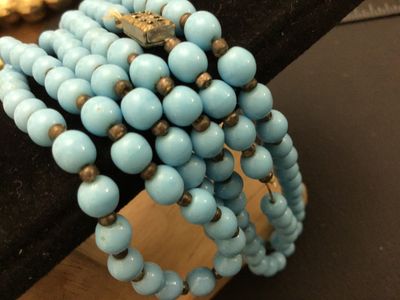Sale Photo Thumbnail #106: Vintage multi-strand long necklace featuring light blue round beads separated by small dark spacer beads. Includes a gold-tone filigree push-in box clasp. Good vintage condition with light wear consistent with age.