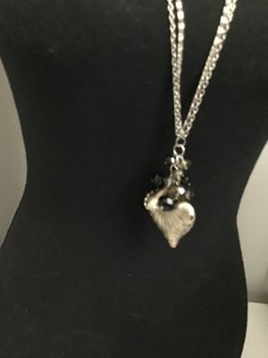 Sale Photo Thumbnail #132: Long silver-tone double-chain necklace featuring a detailed textured nautilus shell pendant clustered with faceted black and smoky glass beads. Good condition with light minor surface wear to the finish.