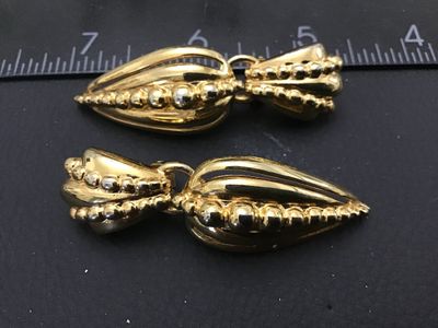 Sale Photo Thumbnail #181: Pair of vintage gold-tone clip-on drop earrings featuring a ribbed, tear-drop shape design with beaded texture accents. Earrings measure approximately 2.5 inches in length. In good condition with minor surface wear consistent with age.