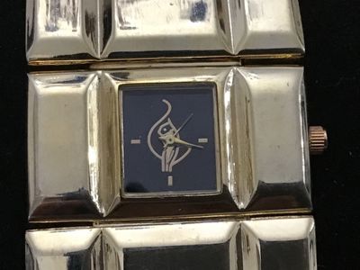 Sale Photo Thumbnail #234: A vintage gold-tone fashion watch featuring a wide, geometric segmented link band and a small square dark dial with stylized graphic logo and minimalist hour markers. Measures Workingapproximately 7.5 to 8 inches in total length. Stainless steel or metal 