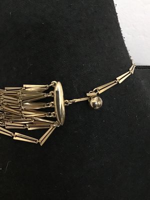 Sale Photo Thumbnail #121: A striking vintage multi-strand statement necklace featuring tiered rows of gold-tone bar-shaped links. Designed with a hook-and-tail clasp featuring a decorative sphere end cap. The necklace shows light wear consistent with age, with all strands intact a