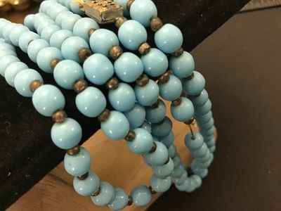 Sale Photo Thumbnail #107: Vintage multi-strand long necklace featuring light blue round beads separated by small dark spacer beads. Includes a gold-tone filigree push-in box clasp. Good vintage condition with light wear consistent with age.