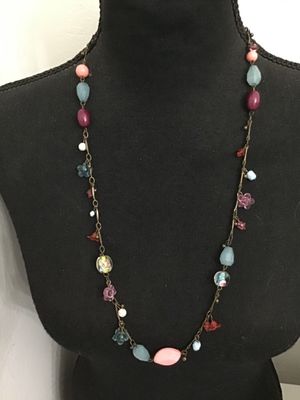 Sale Photo Thumbnail #114: Long brass-tone chain station necklace featuring a mix of colorful glass and acrylic beads, including floral charms, lampwork-style floral glass beads, faceted light blue drops, and pink cabochons. Good pre-owned condition with no visible damage.