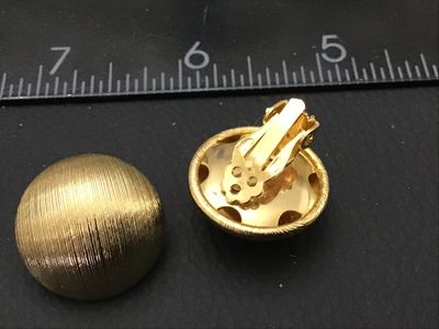 Sale Photo Thumbnail #157: Pair of vintage gold-tone clip-on earrings featuring a textured, ribbed half-dome design. Each earring measures approximately 1 inch in diameter. Clips are intact and functional. Excellent pre-owned condition with minimal signs of wear.